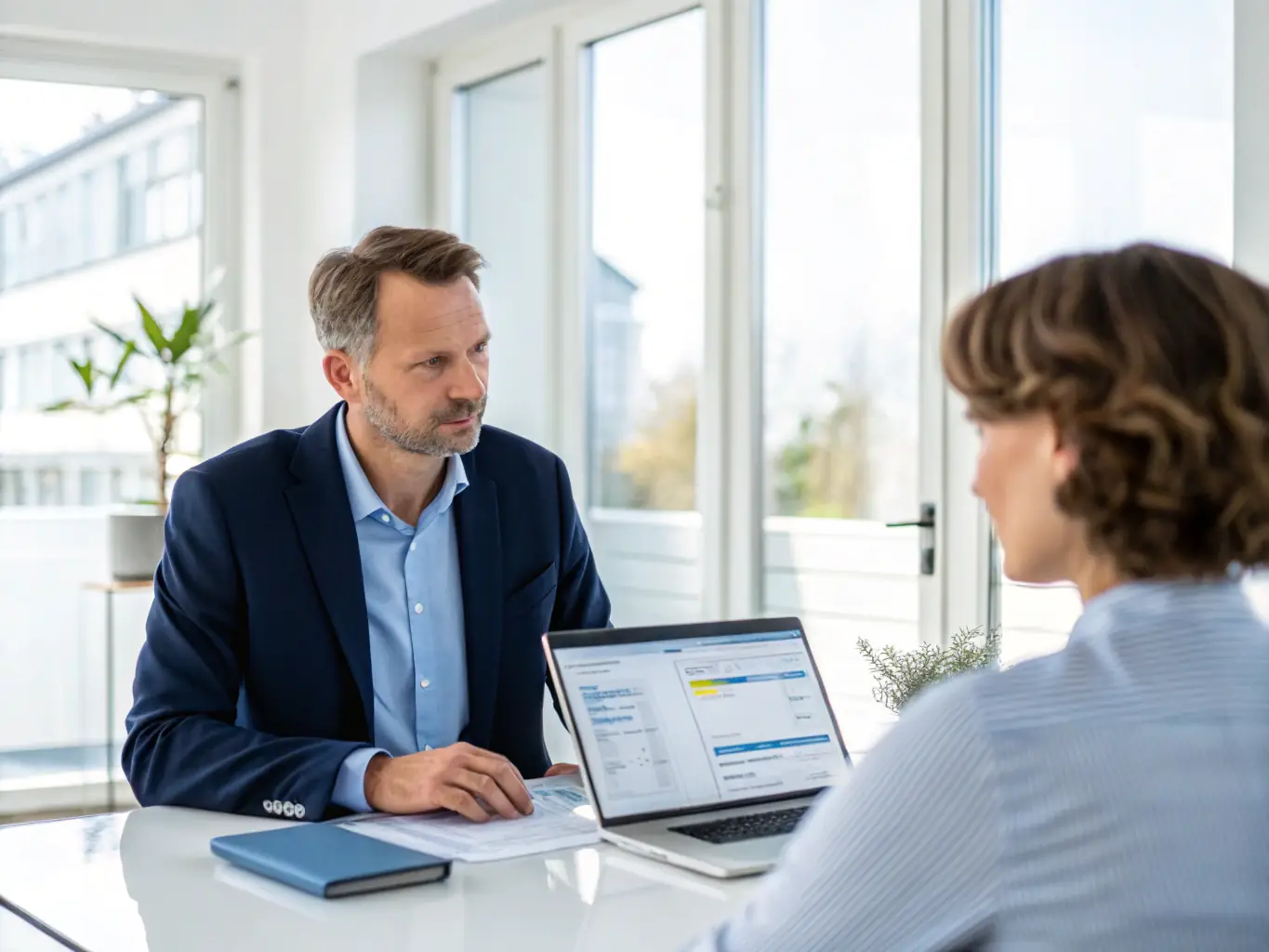 A professional consultant, Robert Stark, is shown advising a client in a modern office setting, reviewing car buying options on a tablet.